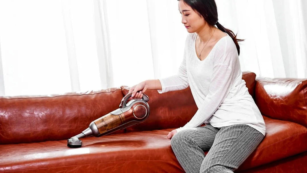 Dùng máy hút bụi cầm tay để hút sạch bụi bẩn bám trên ghế